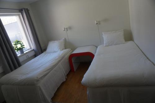 2 camas en una habitación pequeña con ventana en IzKaMaGe Hotel, en Västerås
