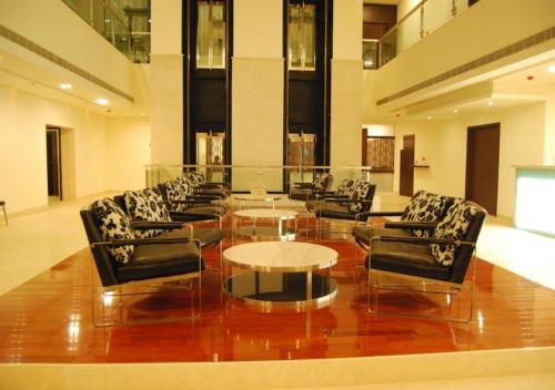a lobby with chairs and tables in a building at Royal Park Kakinada in Kākināda