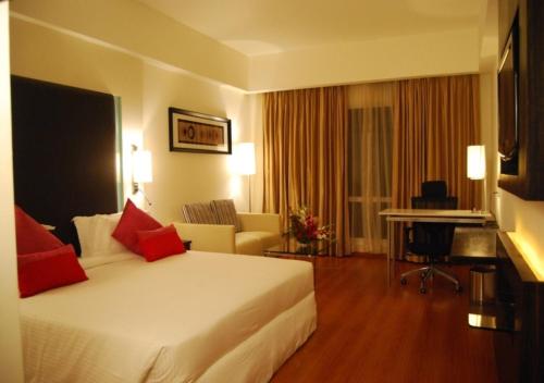 a hotel room with a bed and a desk at Royal Park Kakinada in Kākināda