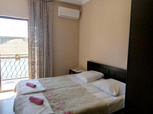 een slaapkamer met een bed met 2 kussens en een raam bij Sunny house Kobuleti in Kobuleti