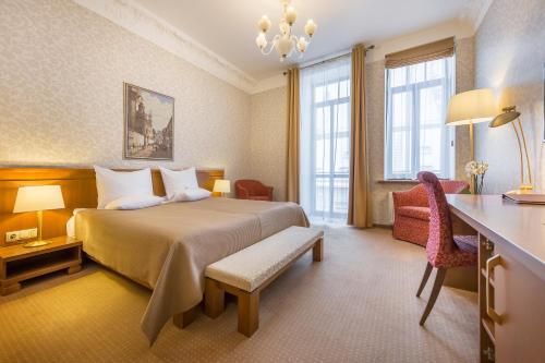 a hotel room with a bed and a desk at Artis Centrum Hotels in Vilnius