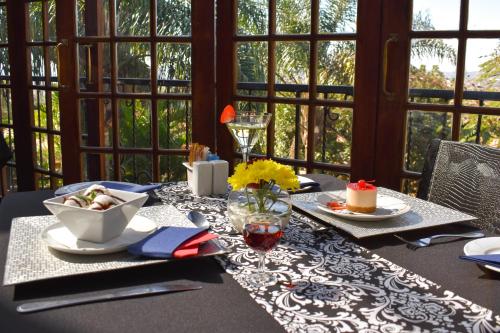 a table with plates of food on top at Waterfalls Boutique Hotel in Pretoria