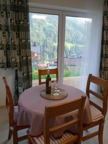 a dining room table with a bottle of wine on it at Amalia Haus in Tux