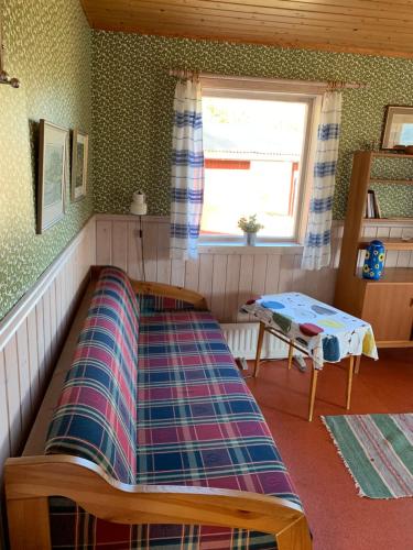 a bed in a room with a window and a table at Utsiktens turistgård in Järkvitsle