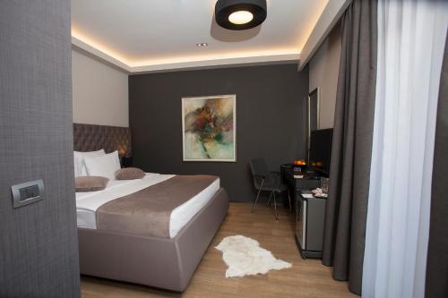 a bedroom with a bed and a desk with a computer at Solun Hotel & SPA in Skopje