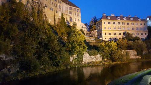 a view of a river in front of a building at Village Romantic Apartments by Český Krumlov - adults only in Střížov