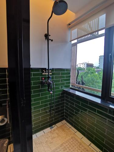a bathroom with a shower with green subway tiles at Hangzhou Lanshe hotel in Hangzhou
