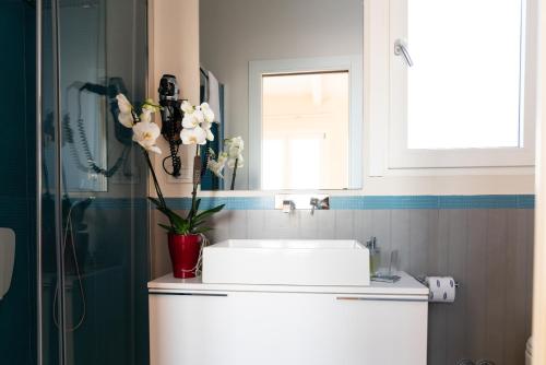 a bathroom with a sink and a vase of flowers at B&B Pellicano Guest House in Reggio Calabria