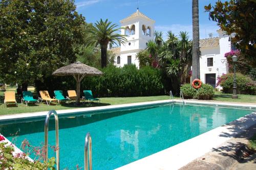 a swimming pool in front of a house at Hotel Cortijo El Esparragal in Gerena