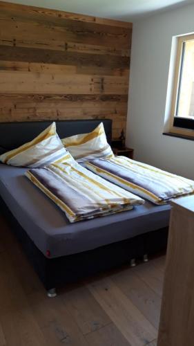 a bed with striped sheets on it in a room at Haus Riefli- Monique in Sankt Anton am Arlberg