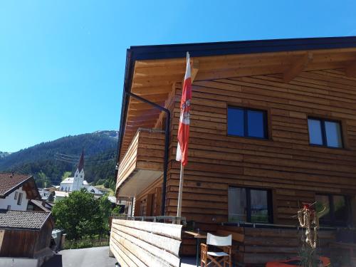 a log building with two flags on it at Haus Riefli- Monique in Sankt Anton am Arlberg