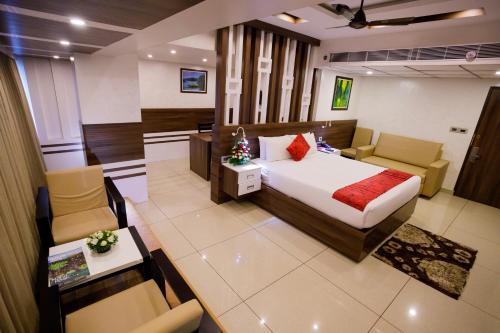 a hotel room with a bed and a table and chairs at The Renai Cochin in Cochin