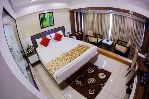 a bedroom with a large bed and a living room at The Renai Cochin in Cochin