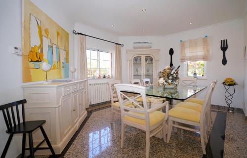 a kitchen with a dining room table and chairs at Vila Luz in Vilamoura
