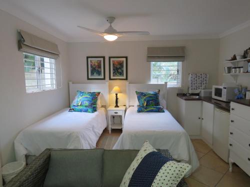 uma sala de estar com duas camas e um sofá em Dolphin Place em Port Shepstone