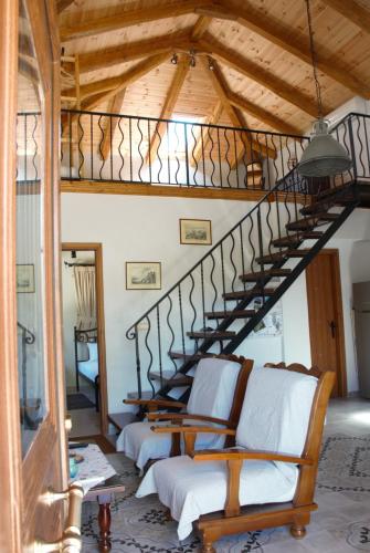 a living room with a spiral staircase in a house at LIORIZA Country Houses in Kalamaki
