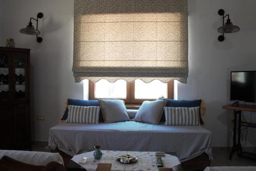 a bedroom with a bed and a window with a window shade at LIORIZA Country Houses in Kalamaki