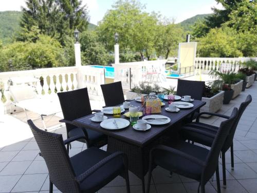 een zwarte tafel en stoelen op een patio bij Guest House Surina App Surina's Green Holiday in Rupa