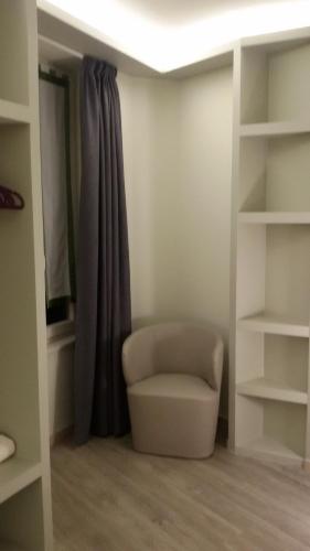 a living room with a chair and a window at Hotel Borgovico in Como