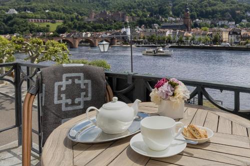 a table with a tea set on top of a balcony at House of Hütter- Heidelberg Suites Boutique in Heidelberg