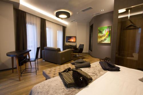 a hotel room with a bed and a living room at Solun Hotel & SPA in Skopje