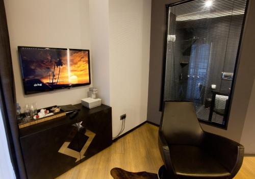 a living room with a chair and a flat screen tv at Solun Hotel & SPA in Skopje