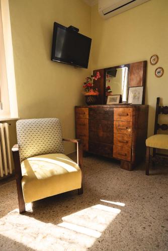 a living room with a chair and a mirror at Villa Liberty B&B in Fano