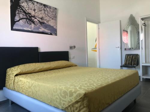 a bedroom with a bed with a yellow bedspread at Il Platano Residenza Rurale in Agropoli