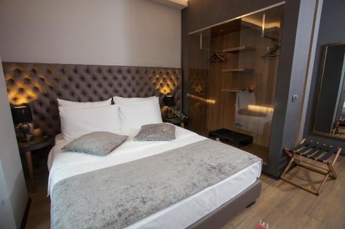 a bedroom with a large bed with two pillows at Solun Hotel & SPA in Skopje