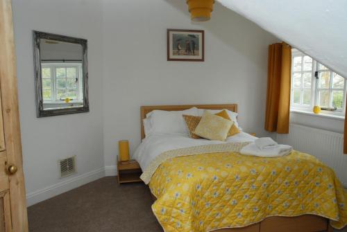 a bedroom with a bed with a yellow blanket at Greysfield Cottage in Chester