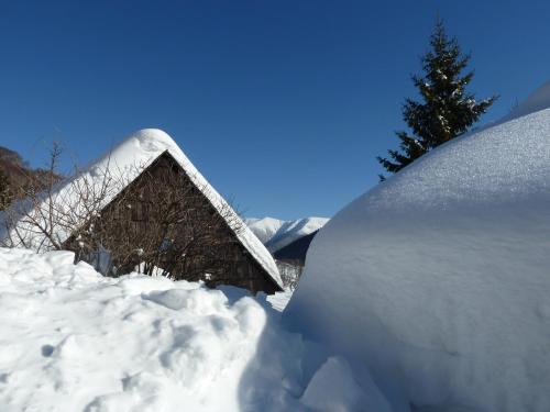 a large pile of snow next to a house at Chalupa Pri vleku. in Donovaly