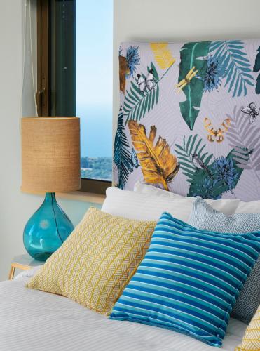 a bed with a blue lamp and pillows on it at Artblue Villas in Tsoukaladhes