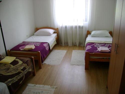 two beds in a small room with a window at Guest House Robi in Međugorje