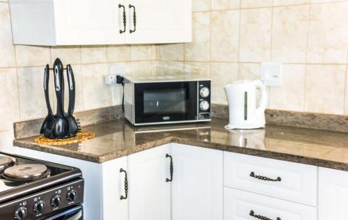 a kitchen counter with a microwave and a stove at Mawusi Bush Lodge in Hoedspruit