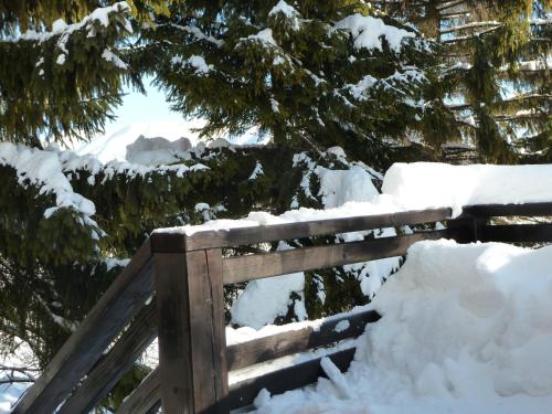 a wooden fence covered in snow next to trees at Chalupa Pri vleku. in Donovaly
