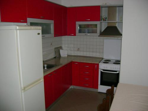 a kitchen with red cabinets and a white refrigerator at Guest House Robi in Međugorje