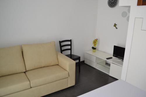 a living room with a couch and a tv at Casa Madalena in Barão de São João