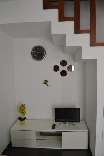 um quarto com uma secretária e um relógio na parede em Casa Madalena em Barão de São João