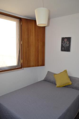 a bed in a room with a window at Casa Madalena in Barão de São João