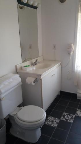 a bathroom with a white toilet and a sink at Motel Shantik in Montebello