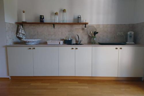 cocina con armarios blancos y encimera en Apartma Dolomiti, en Liubliana