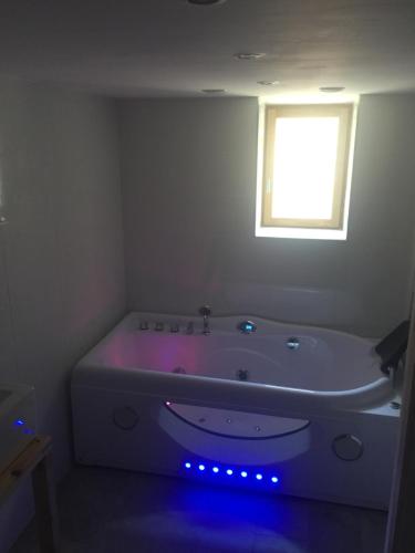 a white bath tub with blue lights in a bathroom at Chambres d’hôtes La Voûte in Volonne
