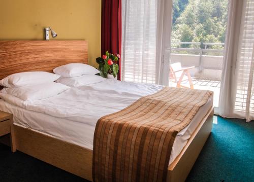a large bed in a bedroom with a balcony at Hotel Veter in Ruše