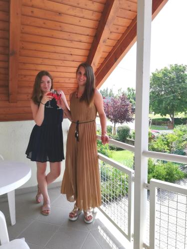 two women standing on a porch taking a picture at St.Flórián Apartman in Keszthely