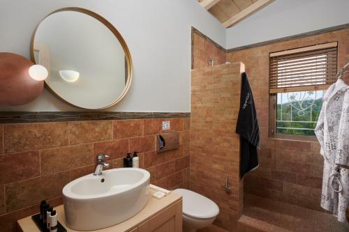 a bathroom with a sink and a mirror at Artblue Villas in Tsoukaladhes