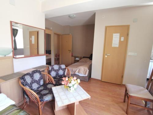 a living room with two chairs and a table with flowers at De Lux Apartments Kosta in Ohrid