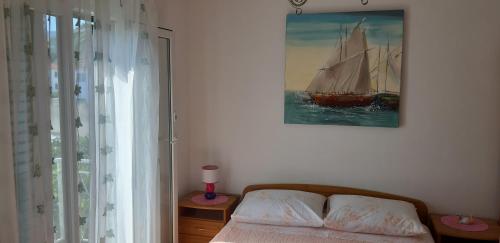 a bedroom with a bed and a sail boat on the wall at Apartman Lorena in Stari Grad