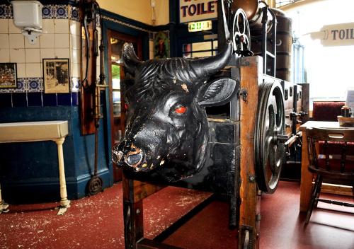 a statue of a black cow on display in a store at Mad O'Rourkes Pie Factory in Dudley