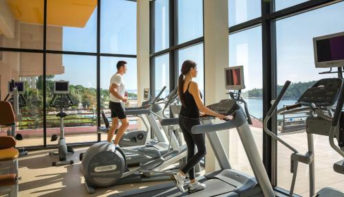 a man and a woman on a treadmill in a gym at Maistra Select All Suite Island Hotel Istra in Rovinj