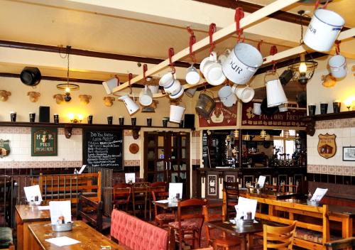 a restaurant with tables and chairs and pots and pans at Mad O'Rourkes Pie Factory in Dudley